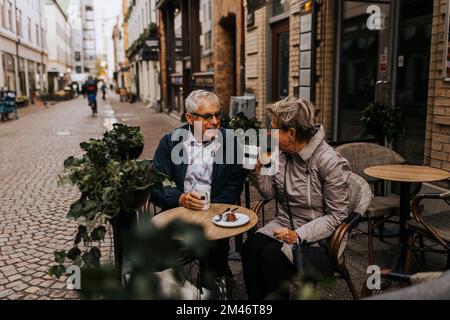 Senior couple drinking coffee in sidewalk cafe Stock Photo