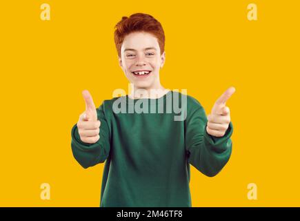 Portrait of happy, toothless, red-haired confident teenager in casual, warm, green sweater. Stock Photo