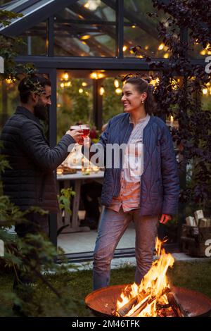 Friends sitting at fire in garden Stock Photo