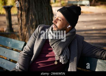 Smiling man sitting on bench Stock Photo
