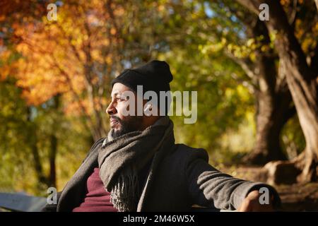Smiling man sitting on bench Stock Photo