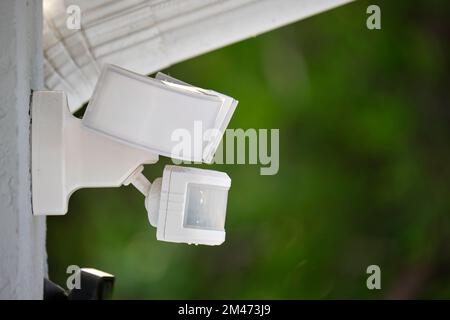 Motion sensor with light detector mounted on exterior wall of private house as part of security system Stock Photo