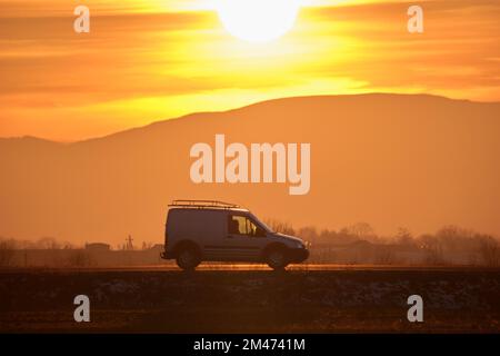 Small cargo van driving on highway hauling goods. Delivery transportation and logistics concept Stock Photo