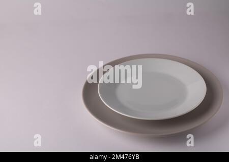 photo of two round plates on top of each other on a white background Stock Photo