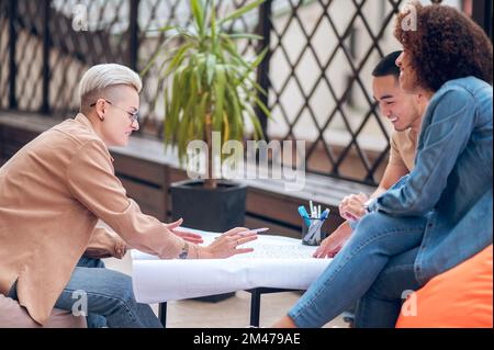 Cheerful architectural team working on a technical drawing Stock Photo
