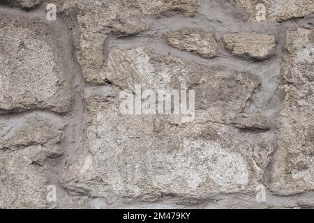 A wall of old stone cemented together. Background, texture. Stock Photo