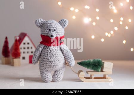 Crocheted white bear with the Christmas tree on the wooden sled Horizontal Stock Photo