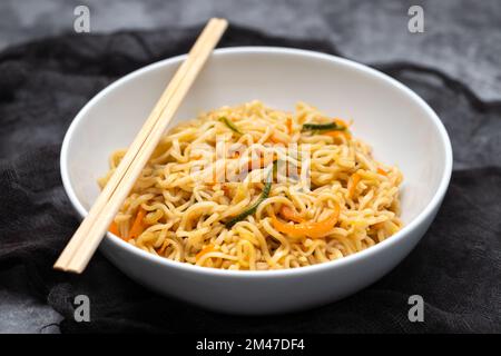 Fresh tasty noodles with vegetables in white bowl Stock Photo