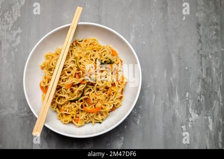 Fresh tasty noodles with vegetables in white bowl Stock Photo