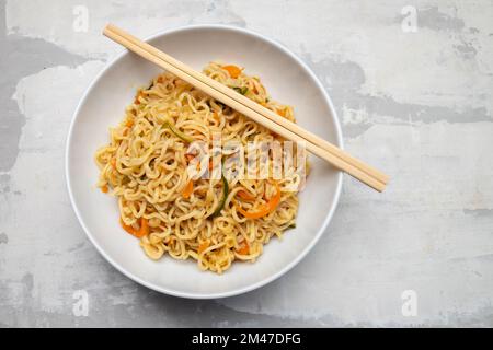 Fresh tasty noodles with vegetables in white bowl Stock Photo