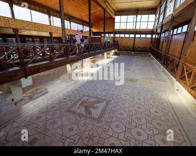 PAPHOS, CYPRUS - NOVEMBER 22: Visitors admire the Mosaics of the House of Dionysus at Pafos Archaeological Park on November 22, 2022 in Paphos, Cyprus. Stock Photo