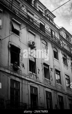 A vertical grayscale shot of an old abandoned building's facade in Rua Augusta, Lisbon, Portugal Stock Photo