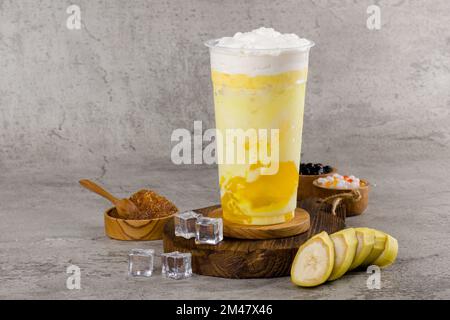 https://l450v.alamy.com/450v/2m47x46/boba-or-tapioca-pearls-is-taiwan-bubble-milk-tea-in-plastic-cup-with-banana-flavor-on-texture-background-summers-refreshment-2m47x46.jpg