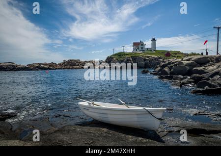 Rowboat in the foreground and Nubble LightHouse in the background, Maine, USA Stock Photo