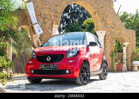 A red smart Fortwo car in the hotel parking on a beautiful sunny day. Stock Photo