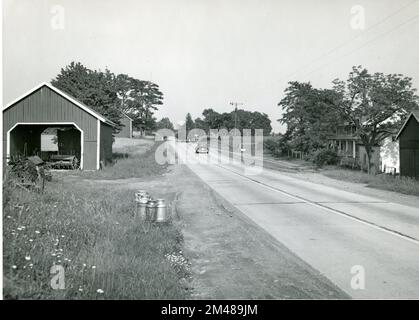 Milk Cans Waiting For Delivery. Original caption: Milk cans waiting for delivery on State Route 27, Maryland. State: Maryland. Place: State Route 27. Stock Photo