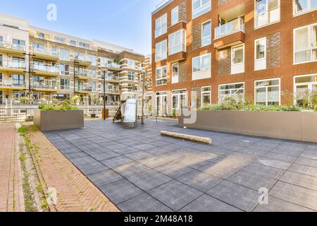 an apartment complex with plants and trees in the foregrounds, on a bright sunny day - stock photo Stock Photo