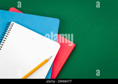 Notebooks on green background, school concept, flat lay. Stock Photo