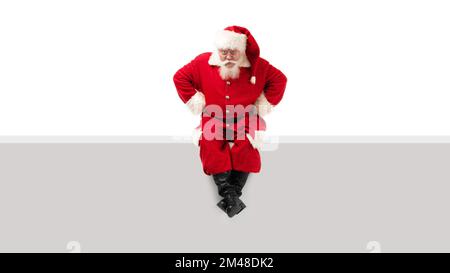 Santa claus sitting on a blank panel and reading a book isolated on ...