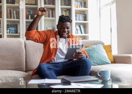 African american plump guy student passing test online Stock Photo