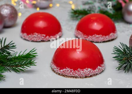 Mousse cakes in the form of Christmas hats on light background for New Year party Stock Photo