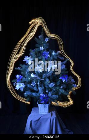 Christmas tree with decorations. Light around the tree. Stock picture. Stock Photo