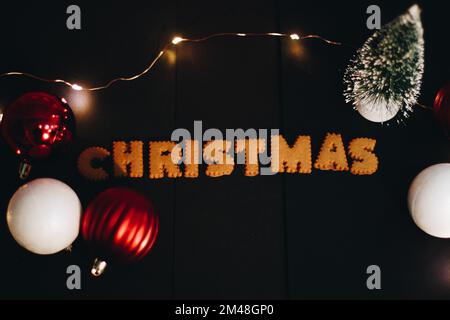 Gingerbread words Merry Christmas on old black table with Christmas decorations Stock Photo