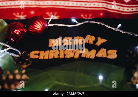 Gingerbread words Merry Christmas on old black table with Christmas decorations Stock Photo