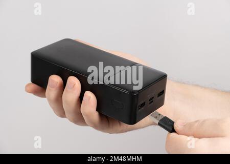 Connecting the cord to the power bank. Charging gadgets from the power bank. Stock Photo
