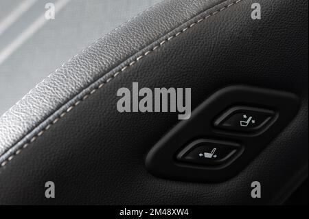 Car seat adjustment buttons on leather chair close up view Stock Photo