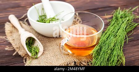 cup of tea from horsetail, made from fresh potion, from pharmacy mortar. Horsetail infusions are used as diuretic for edema Stock Photo