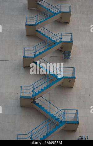 Fire escapes on a gray house wall. Stock Photo