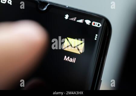 A man holding smartphone with one new message on a screen. Closeup shot. all the graphics are made up Stock Photo