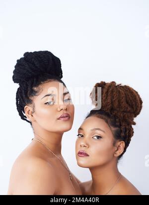 We all about keeping it natural. Studio shot of two beautiful young women posing against a grey background. Stock Photo