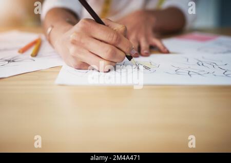 The hands of a designer. an unrecognizable young fashion designer working on her designs in her workshop. Stock Photo