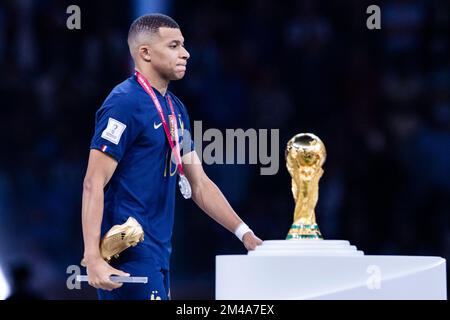 Lusail, Qatar. 18th Dec, 2022. Soccer: World Cup, Argentina - France, final round, final, Lusail Stadium, France's Kylian Mbappe walks past the World Cup trophy during the award ceremony. Credit: Tom Weller/dpa/Alamy Live News Stock Photo