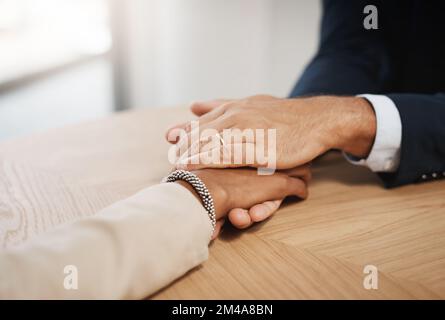 Im always willing to lend a helping hand where needed. Closeup shot of two unrecognizable businesspeople holding hands in an office. Stock Photo