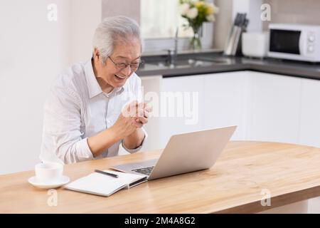 Senior Chinese man using laptop at home Stock Photo