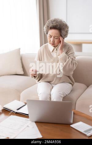 Senior Chinese woman suffering from headache Stock Photo