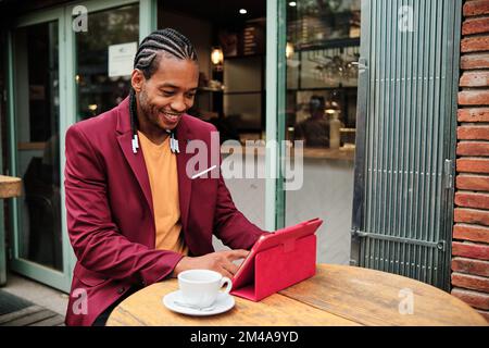 African man using a tablet in a cafeteria Stock Photo