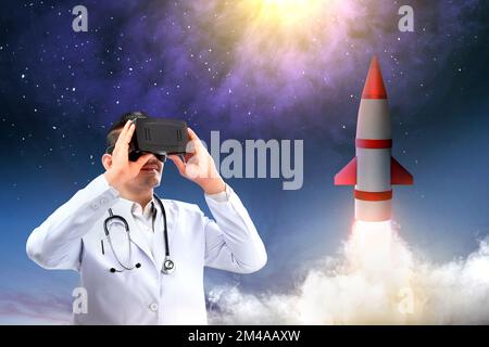Asian male doctor with a stethoscope using virtual reality with a flying rocket in space. National Science Day Stock Photo
