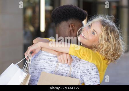 close up of smiling young multiethnic couple hugging outdoors Stock Photo