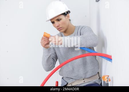 female electrician installing a wall socket Stock Photo