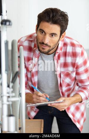 young handsome and serious man repairing a wheelchair Stock Photo