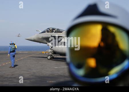 Rea Sea, December 19, 2022. - A firefighting personnel member looks on (R) as French navy flight deck crew operate near a Rafale aircraft fighter jet aboard the French aircraft carrier Charles de Gaulle, sailing between the Suez canal and the Red Sea on December 19, 2022. - French President Emmanuel Macron will join the French aircraft carrier Charles de Gaulle on December 19, 2022 for the traditional Christmas party with the troops, before attending a regional conference in Jordan on December 20, the Elysee presidential palace announced. Photo by Ludovic Marin/pool/ABACAPRESS.COM Stock Photo