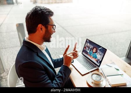 Businessman have a business meeting via video call and communicates using sign language in cafe Stock Photo