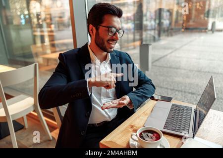 Businessman have a business meeting via video call and communicates using sign language in cafe Stock Photo