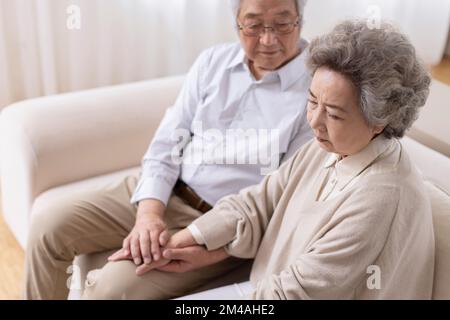 Senior Chinese man consoling his wife Stock Photo