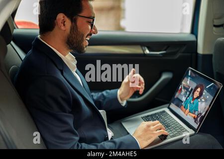 Businessman have a business meeting via video call while riding in car to office Stock Photo