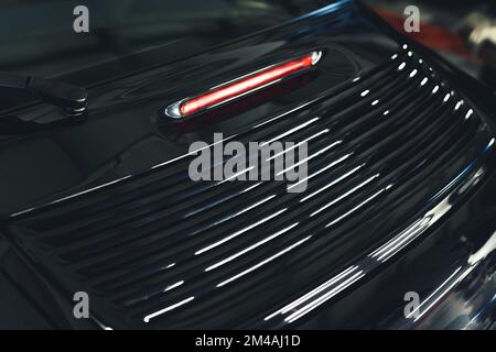 Close up of tail light ant trunk detail of black sports car parked inside garage. Car maintenance concept. Horizontal indoor shot. High quality photo Stock Photo